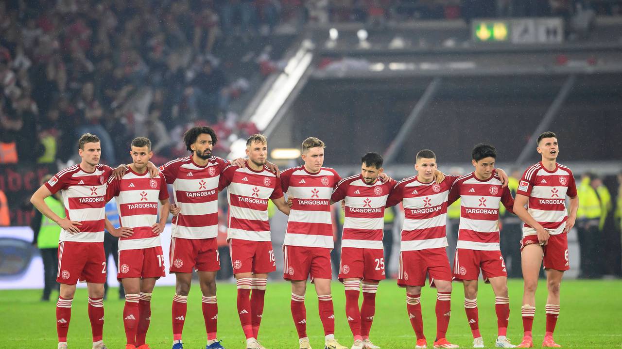 Die Spieler von Fortuna Düsseldorf stehen beim Elfmeterschießen im Relegations-Rückspiel gegen den VfL Bochum Arm in Arm zusammen.