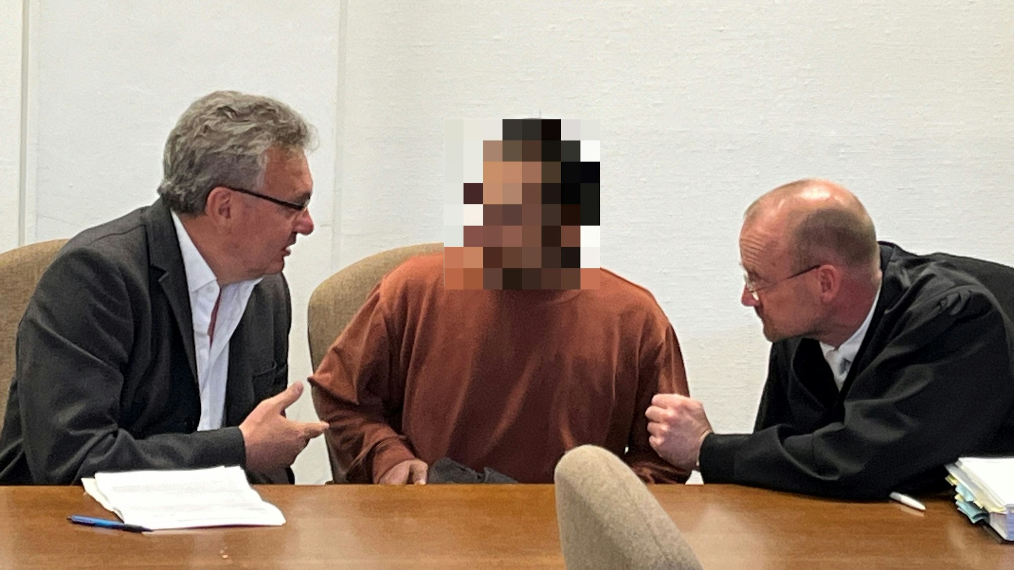Der Angeklagte sitzt im Gericht mit seinen Verteidigern.