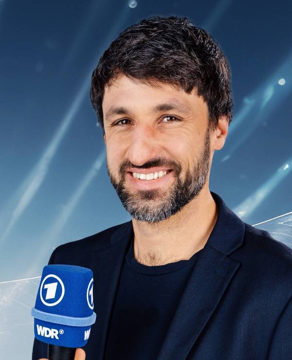 Thomas Broich hält ein ARD-Mikro in der Hand.