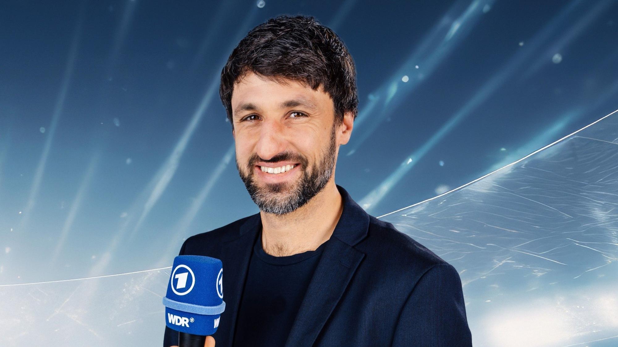 Thomas Broich hält ein ARD-Mikro in der Hand.