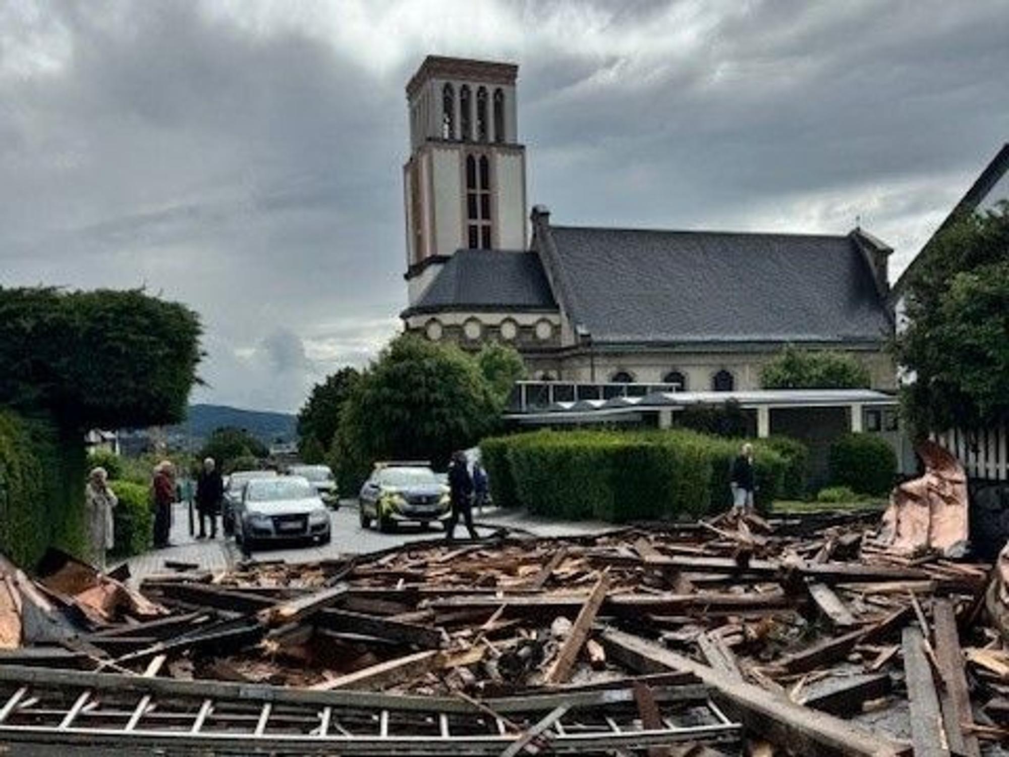 Trümmer des Kirchturmdaches liegen auf der Straße. Ein heftiger Wind hat in Hagen zahlreiche Dächer beschädigt und Bäume umgeweht.