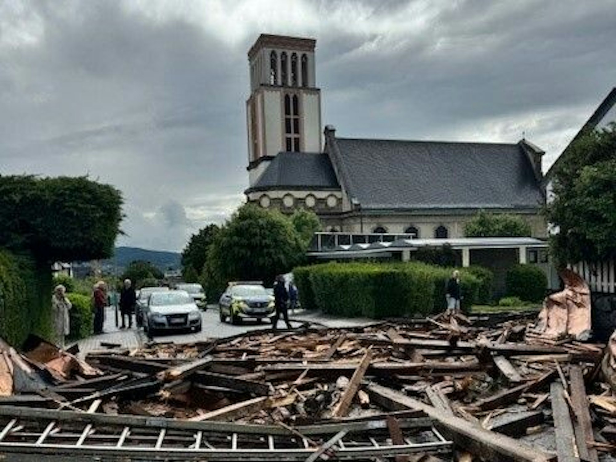 Trümmer des Kirchturmdaches liegen auf der Straße. Ein heftiger Wind hat in Hagen zahlreiche Dächer beschädigt und Bäume umgeweht.