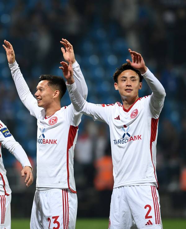 Die Düsseldorf-Profis Ao Tanaka, Shinta Appelkamp und Takashi Uchino jubeln gemeinsam nach dem Relegations-Spiel beim VfL Bochum.