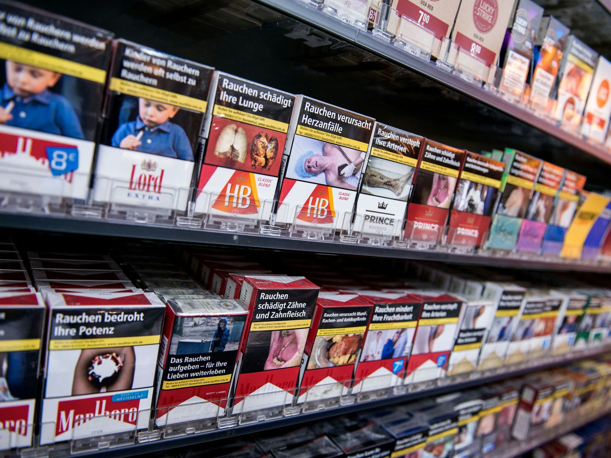 Zahlreiche Zigarettenpackungen stehen in einem Kiosk im Regal.