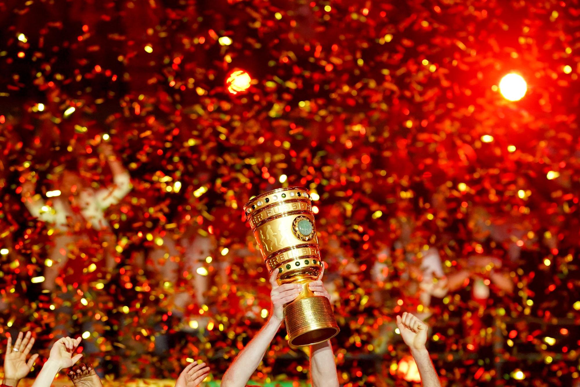 Profis von Bayer Leverkusen recken den DFB-Pokal im Konfettiregen in die Höhe.