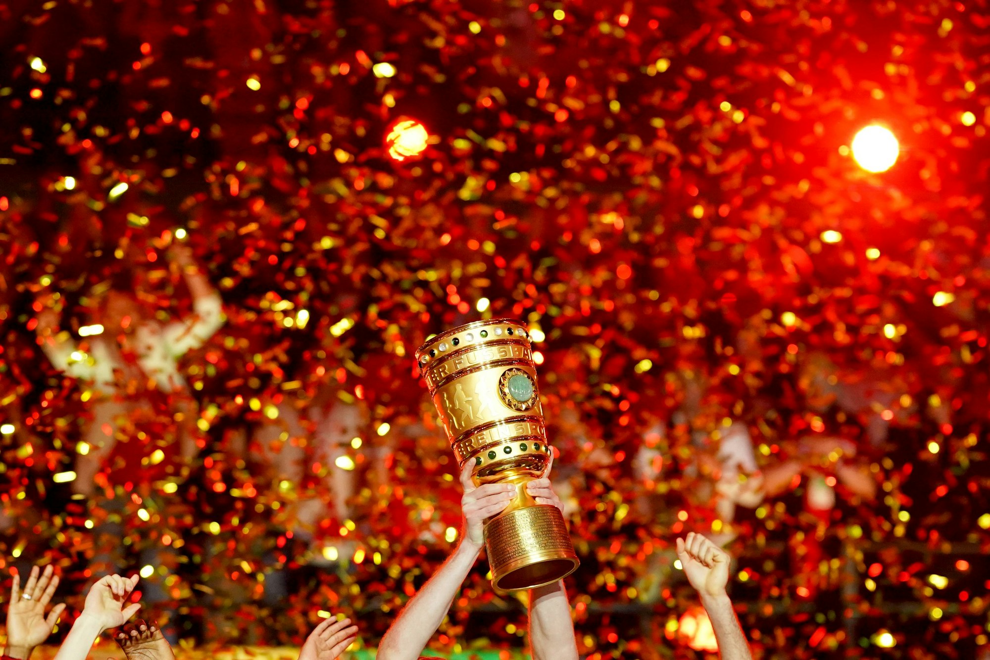 Profis von Bayer Leverkusen recken den DFB-Pokal im Konfettiregen in die Höhe.