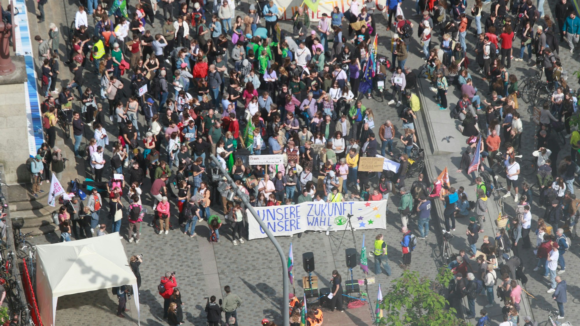 Demonstrierende halten ein Plakat mit der Aufschrift „Unsere Zukunft, unsere Wahl“ vor sich.