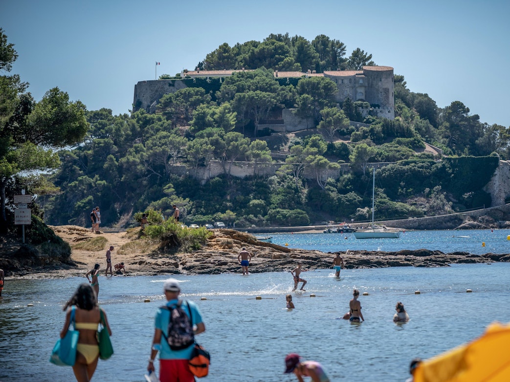 Badegäste schwimmen unterhalb der Sommerresidenz des Staatschefs von Frankreich, Macron, dem Fort de Bregancon am Mittelmeer.