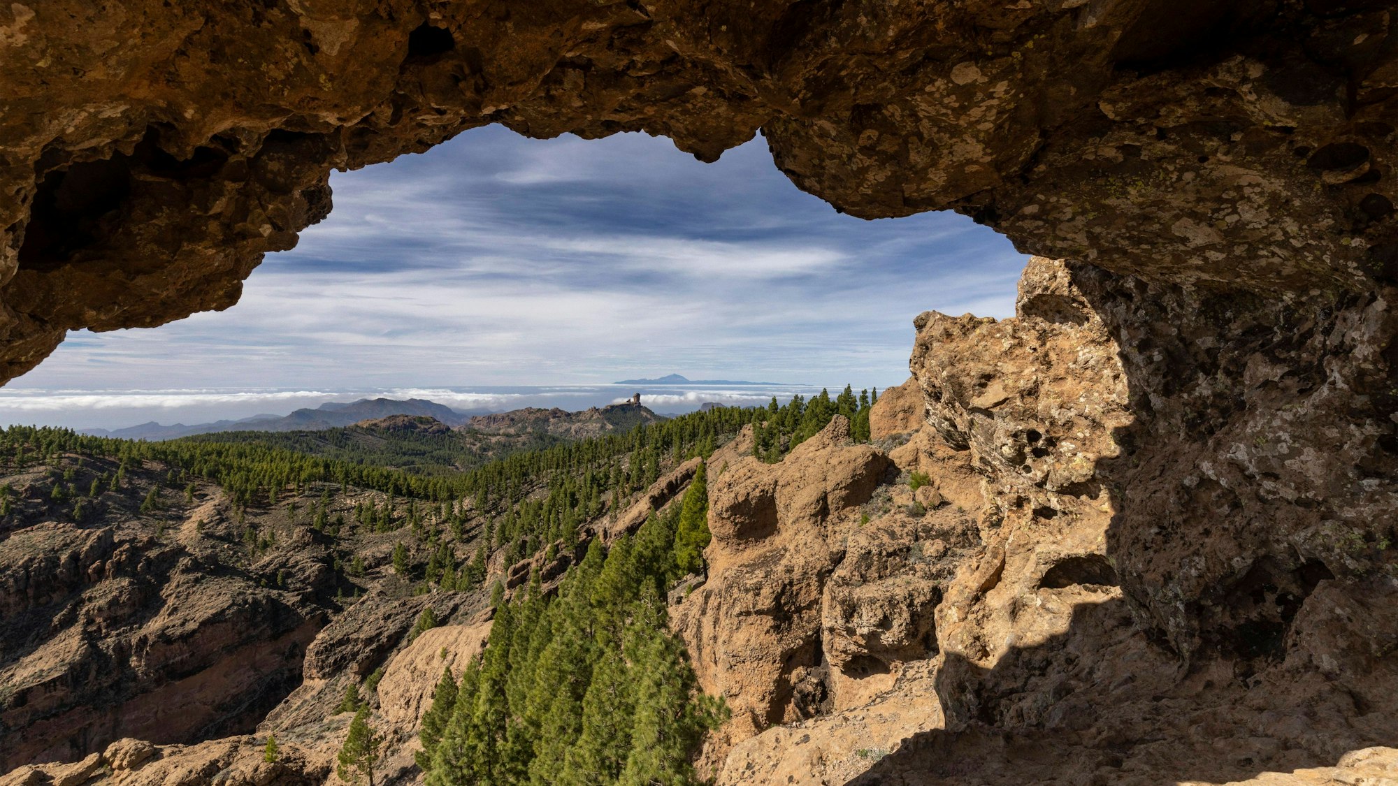 Blick durch Felsbogen zum Roque Nublo und zum Berggipfel Teide auf der Nachbarinsel Teneriffa.
