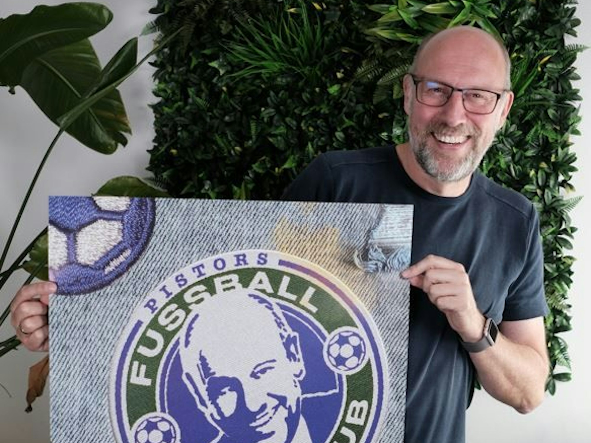 Sven Pistor grinst und hält ein Plakat in die Kamera.