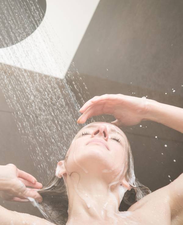 Eine Frau steht unter der Dusche