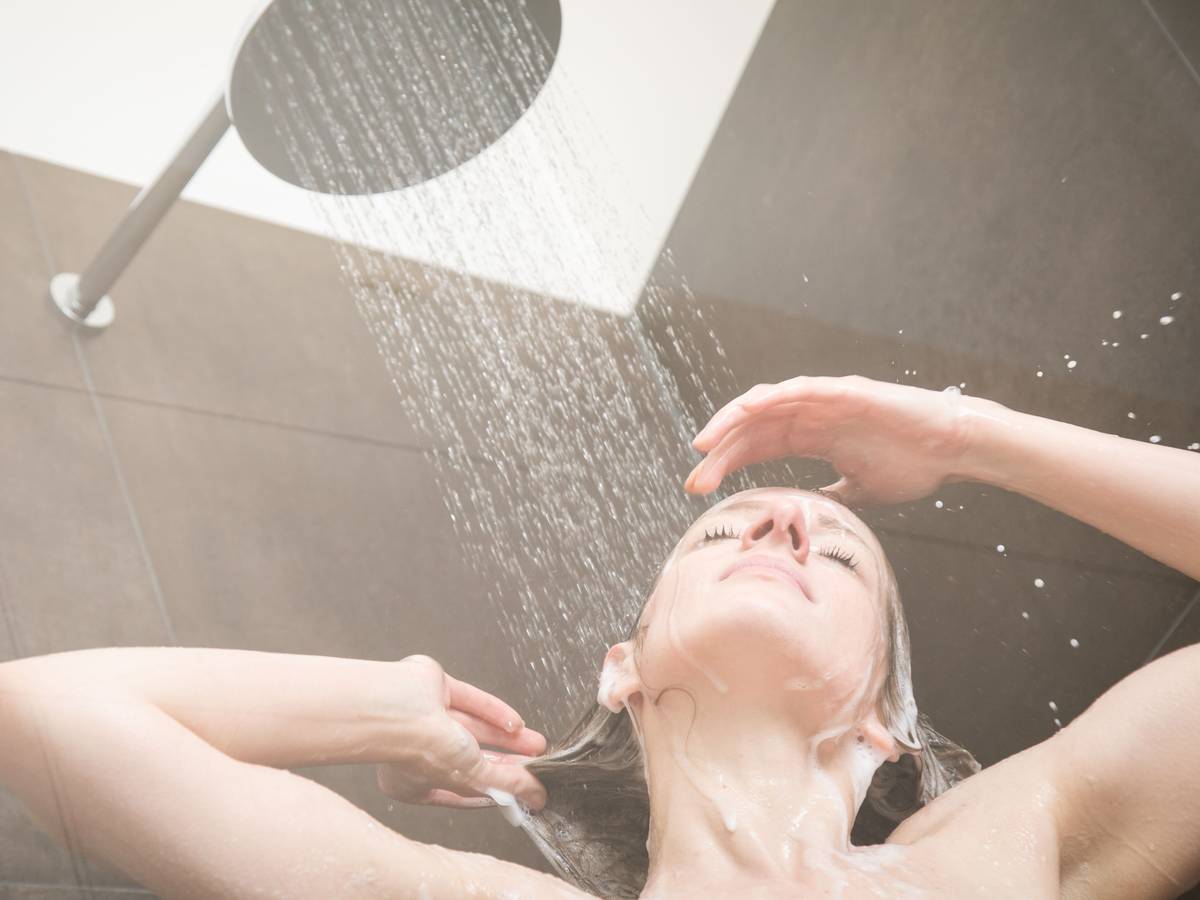 Eine Frau steht unter der Dusche