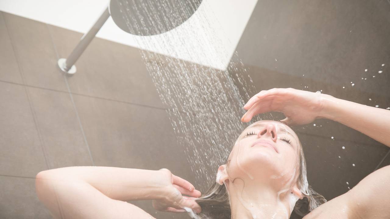 Eine Frau steht unter der Dusche