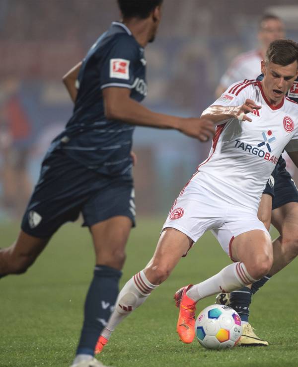 Fortuna-Sechser Yannik Engelhardt (M.) setzt sich robust gegen Kiels Philipp Sander durch.