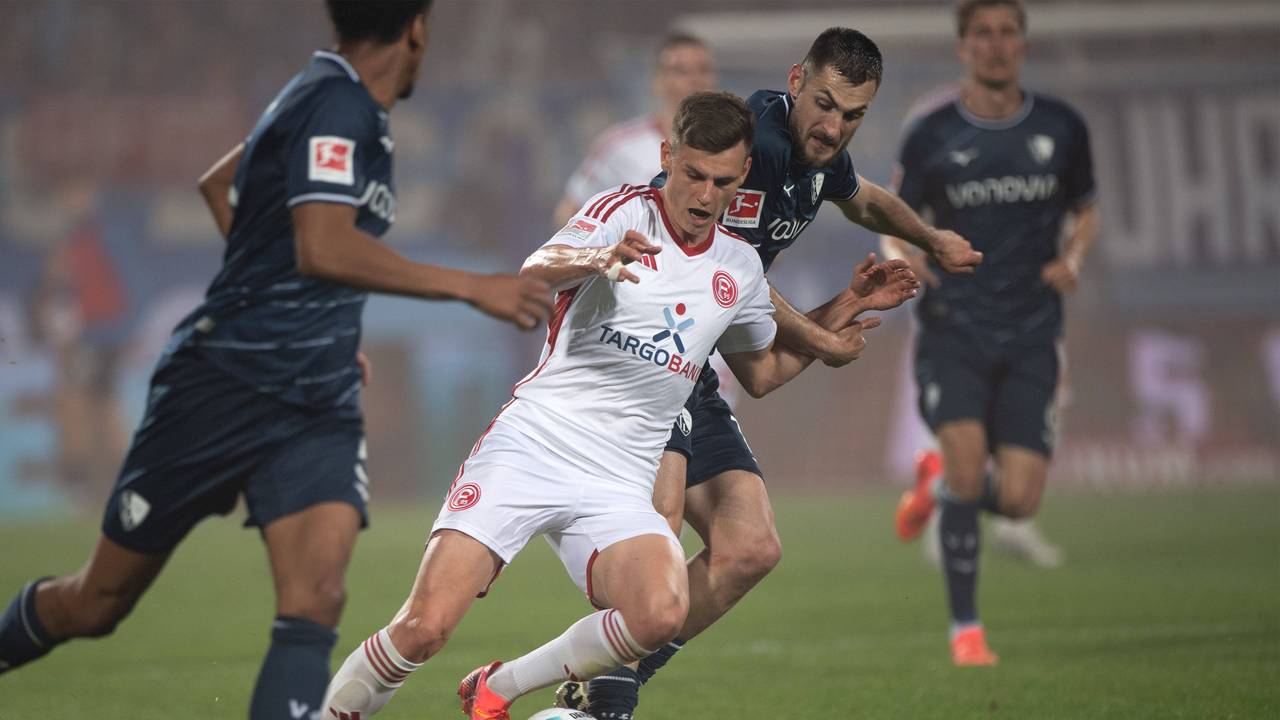 Fortuna-Sechser Yannik Engelhardt (M.) setzt sich robust gegen Kiels Philipp Sander durch.