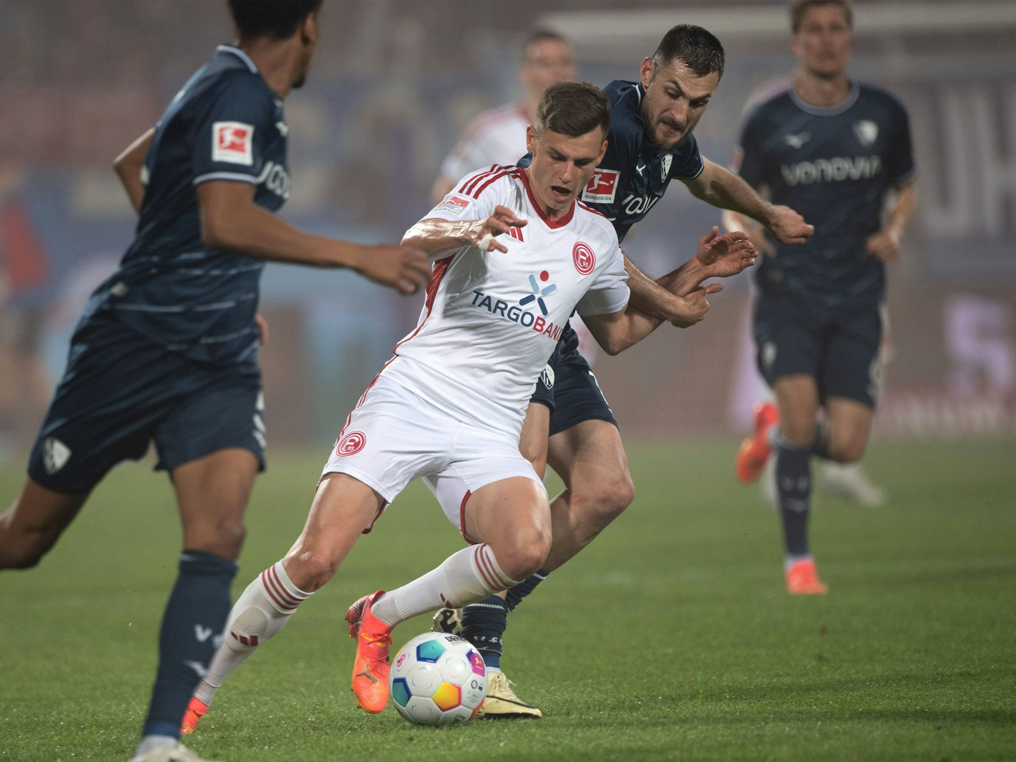 Fortuna-Sechser Yannik Engelhardt (M.) setzt sich robust gegen Kiels Philipp Sander durch.