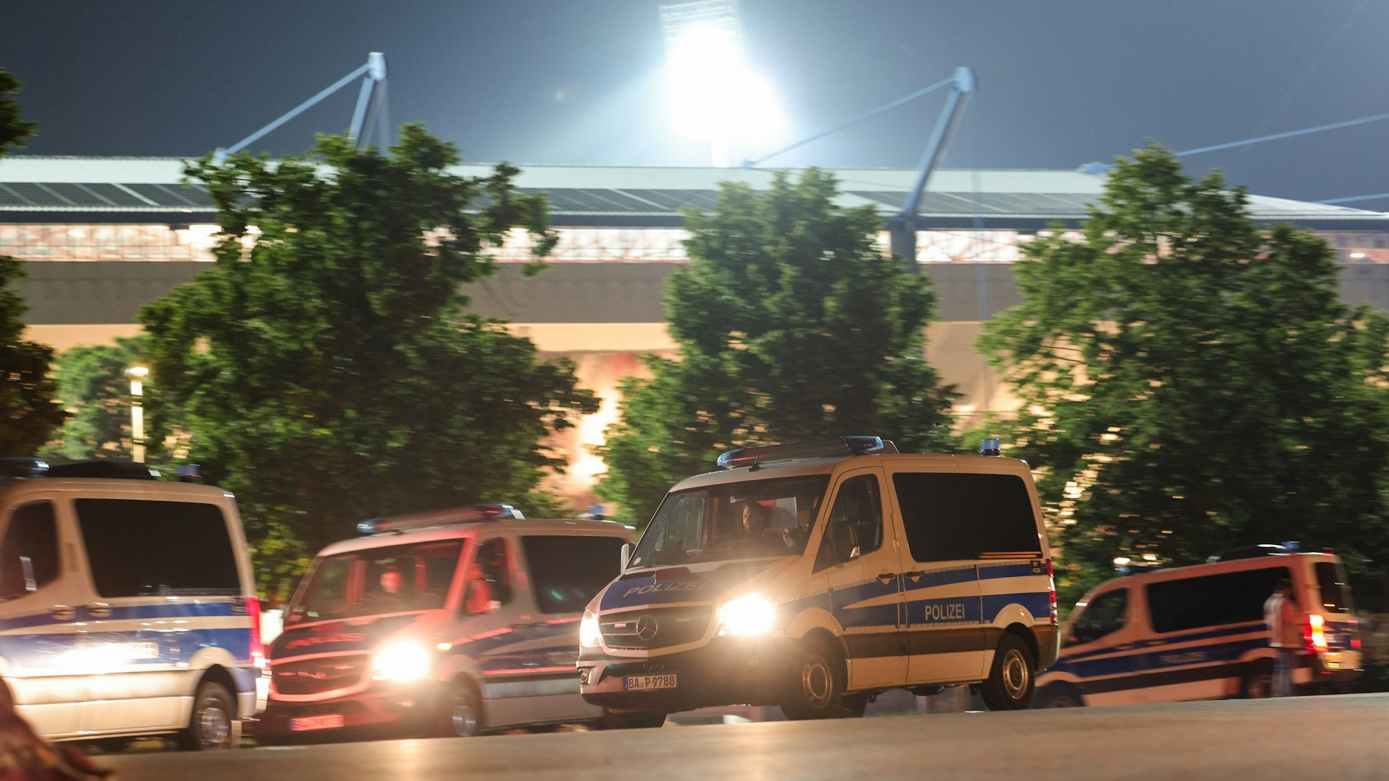 Einsatzkräfte der Polizei sichern eine Straße neben dem Stadion.