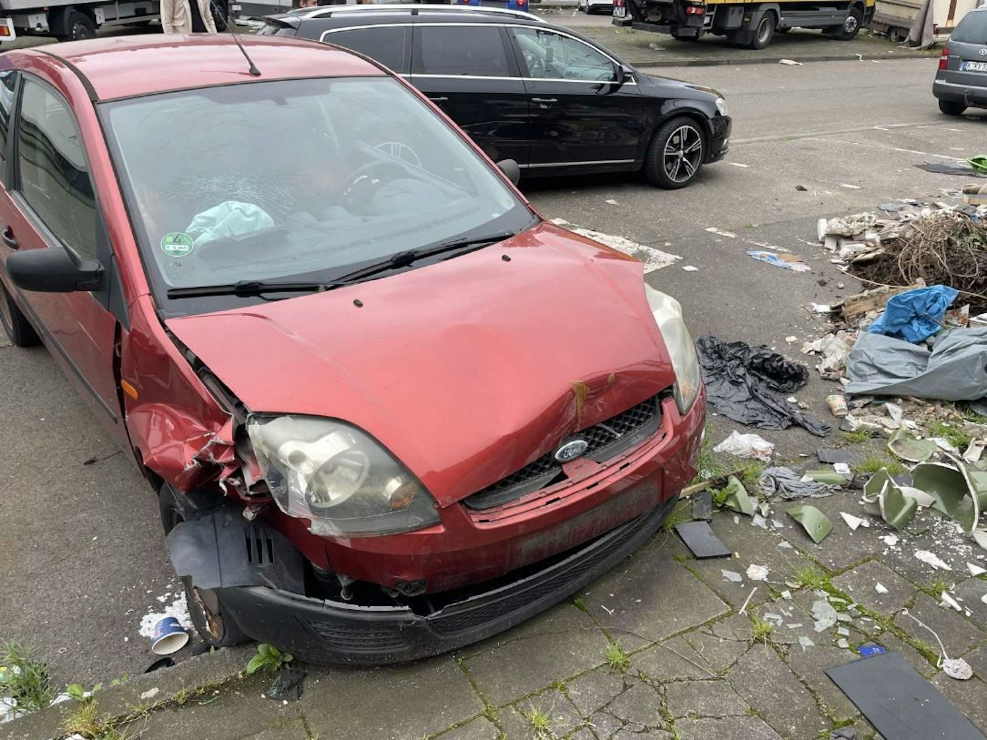 Foto eines kaputten roten Autos der Marke Ford in Köln.