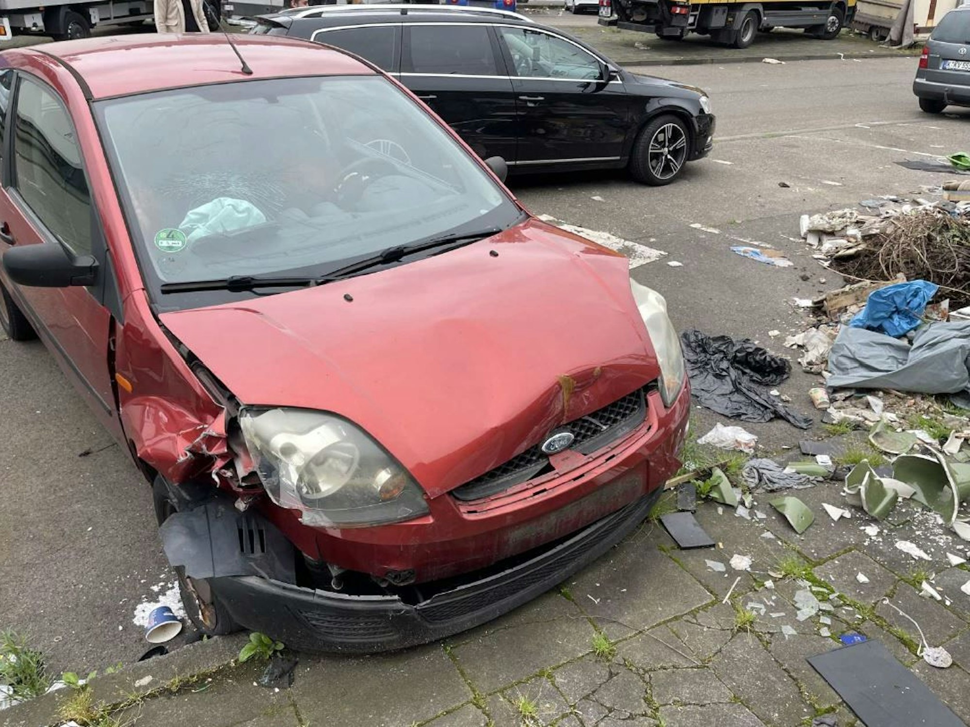 Foto eines kaputten roten Autos der Marke Ford in Köln.