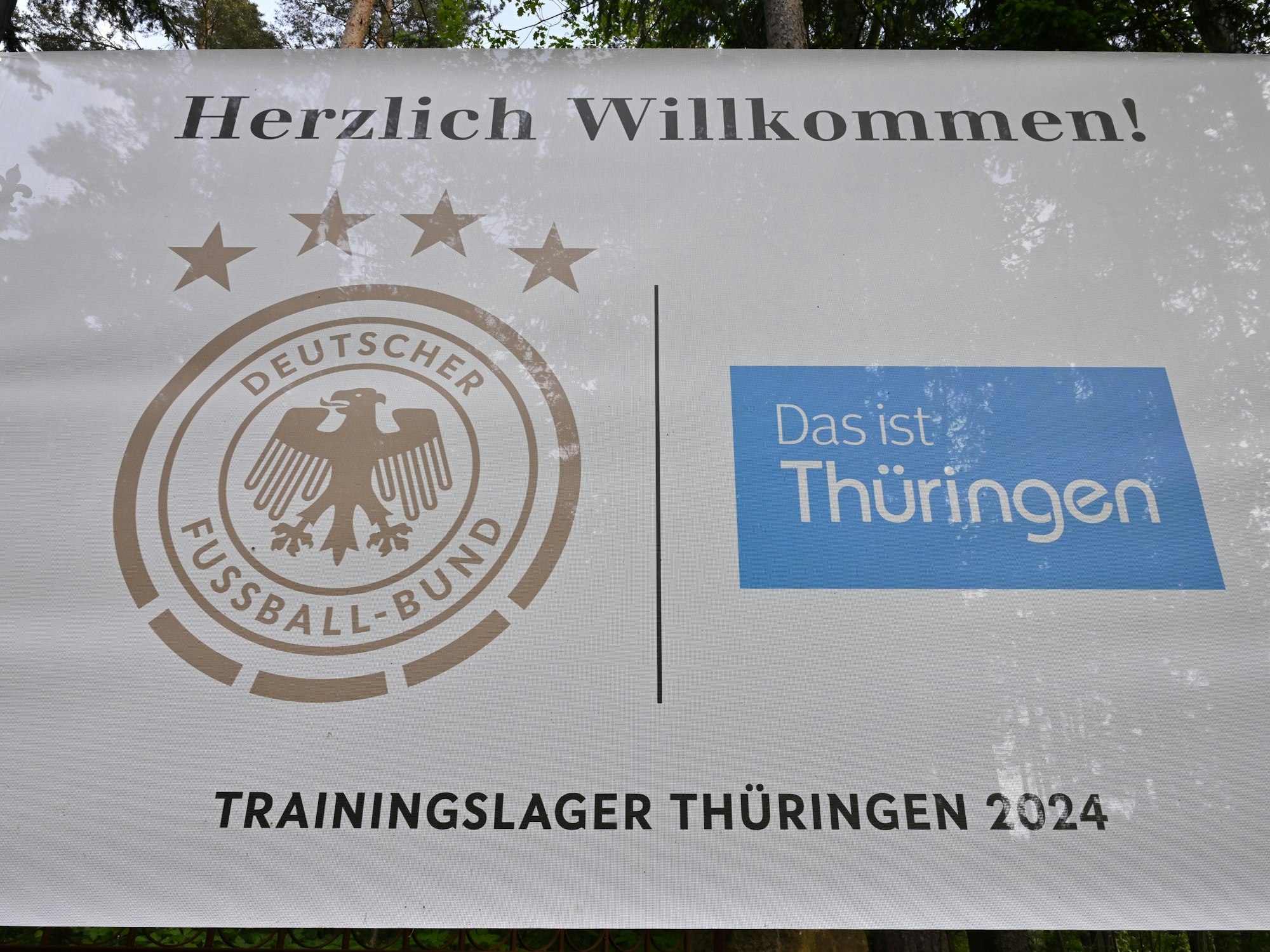 Ein Banner mit dem DFB-Logo und der Aufschrift ·Trainingslager Thüringen 2024· hängt an der Einfahrt zum Spa & Golf Resort Weimarer Land.