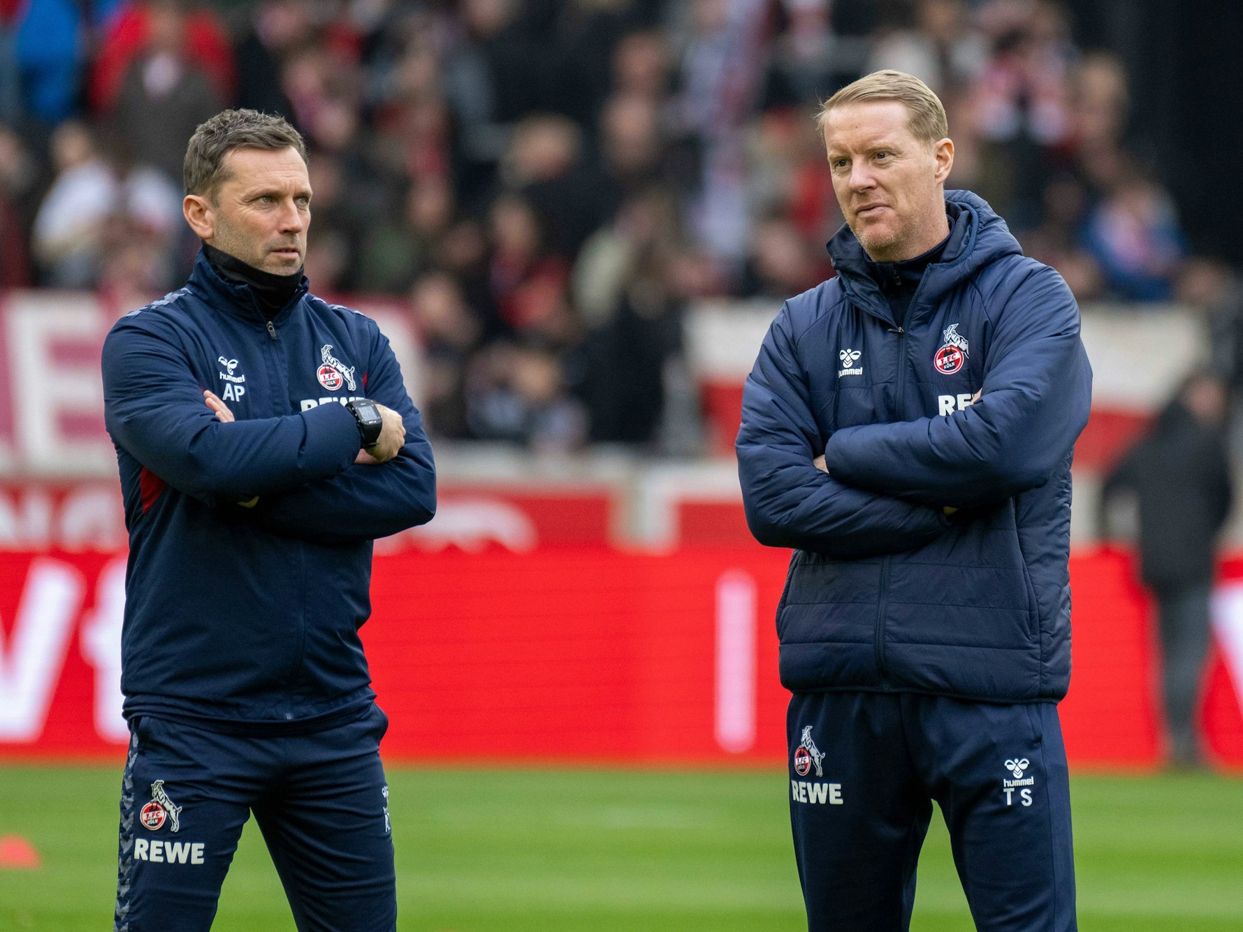 Ex-FC-Trainer Timo Schultz und sein Co Andre Pawlak stehen mit verschränkten Armen auf dem Spielfeld.
