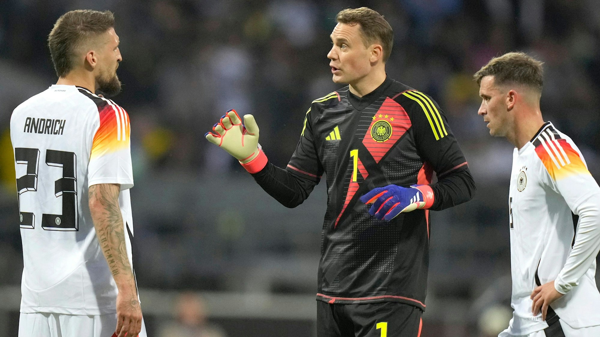 Manuel Neuer spricht mit Robert Andrich und Joshua Kimmich.