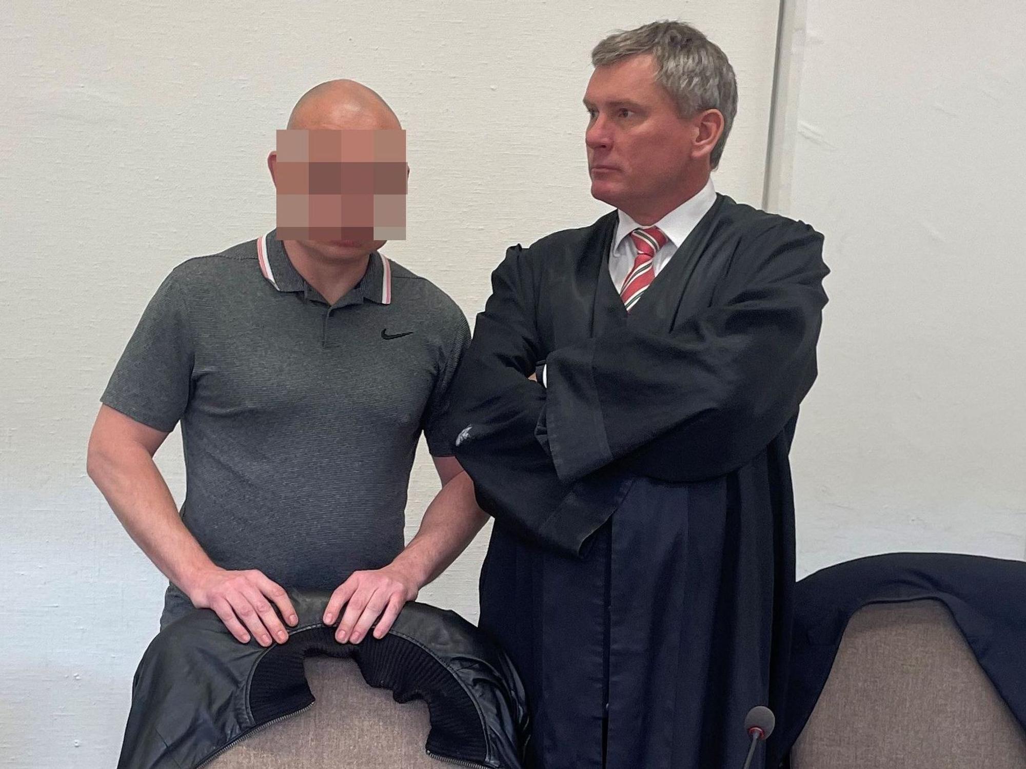 Der Angeklagte steht im Gerichtssaal neben seinem Anwalt.