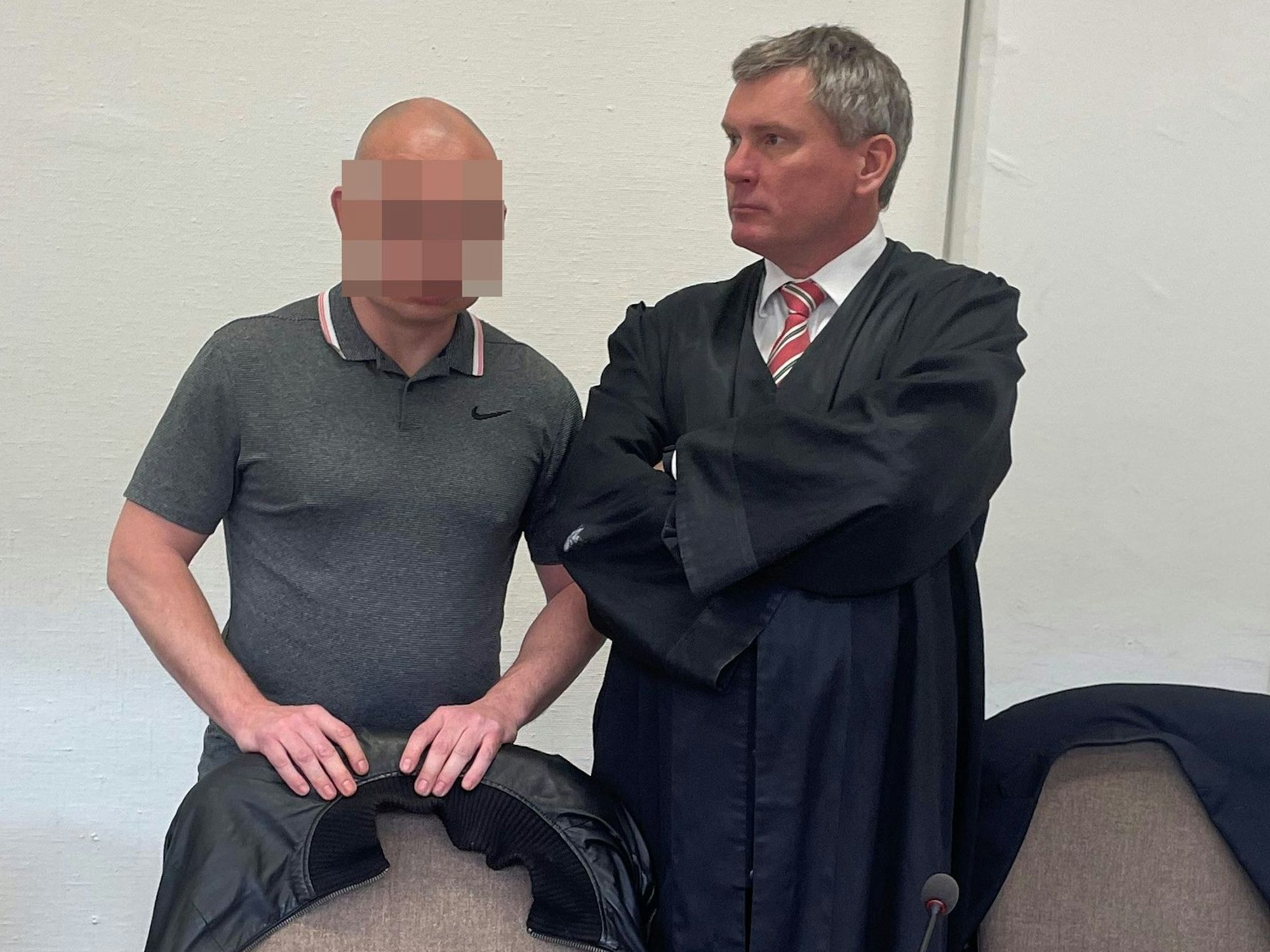 Der Angeklagte steht im Gerichtssaal neben seinem Anwalt.