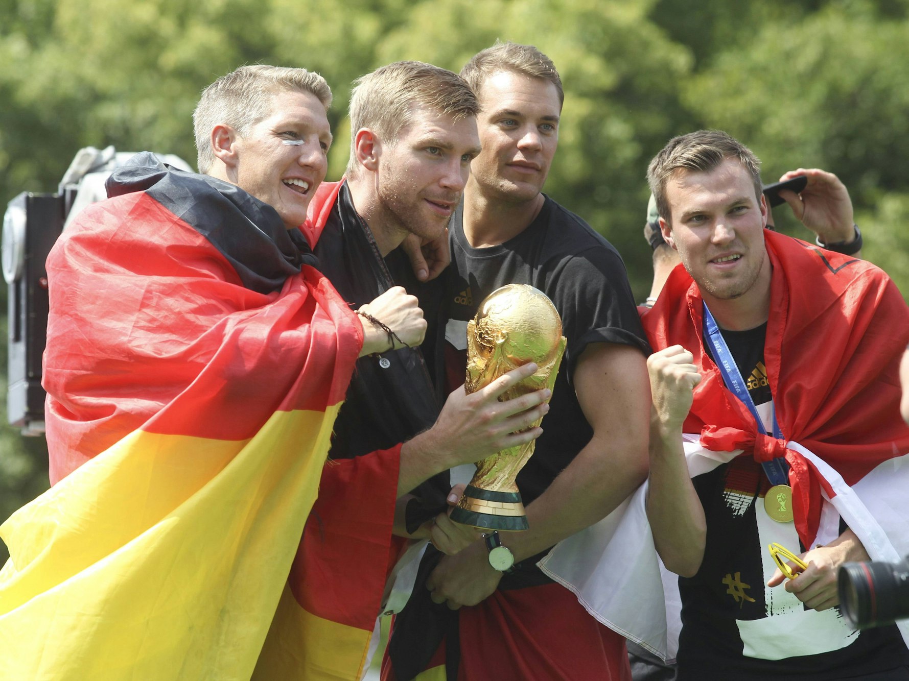 Die Weltmeister Bastian Schweinsteiger, Per Mertesacker, Manuel Neuer und Kevin Großkreutz (v.l.) am 15. Juli 2014 auf der Siegesfeier am Brandenburger Tor in Berlin.
