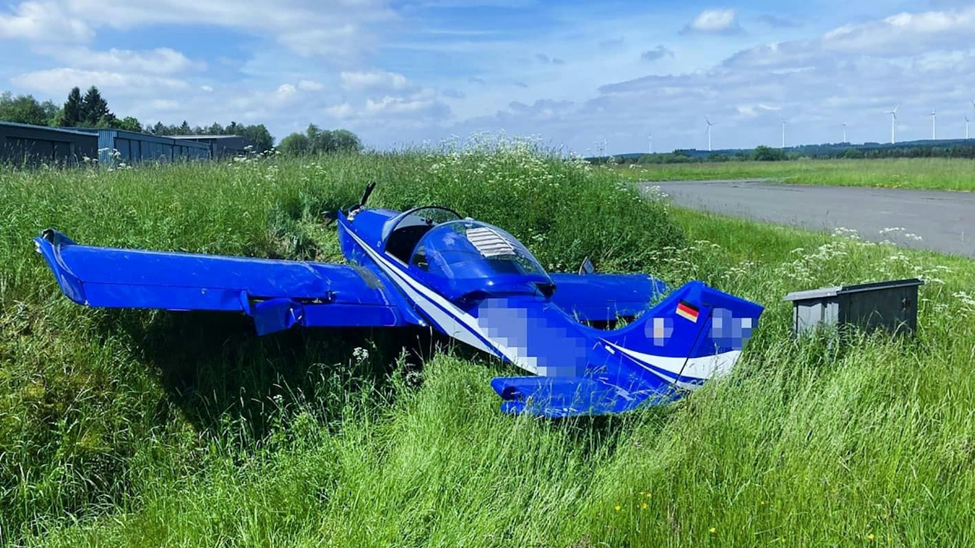 Blaues Ultraleichtflugzeug im Graben.