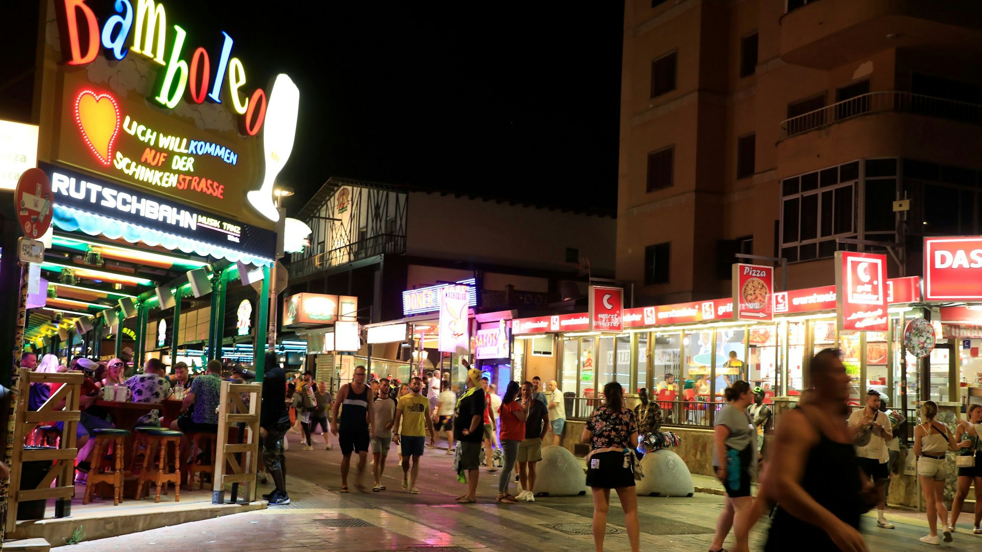 Menschen auf der Schinkenstraße am Strand von Arenal (2023): In Arenal wurden Migranten von einem wütenden Mob verfolgt.