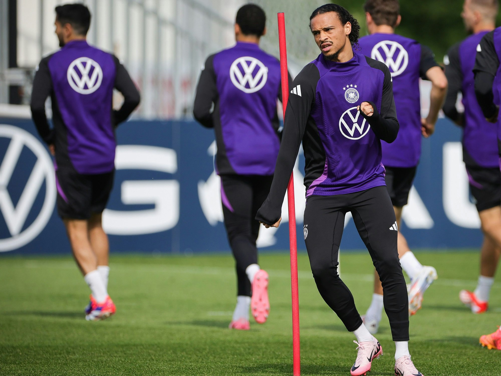 Leroy Sané (M.) und weitere Nationalspieler beim Aufwärmen.