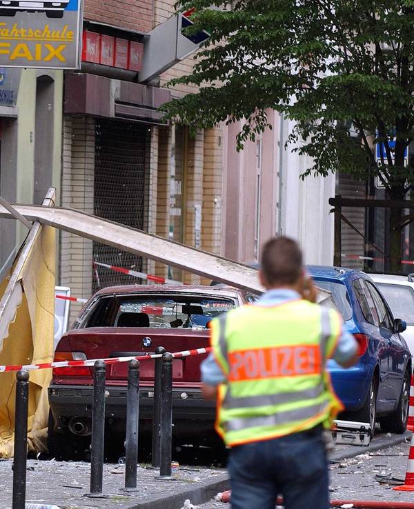 Ein Polizist steht nach einer Explosion an einem Tatort.