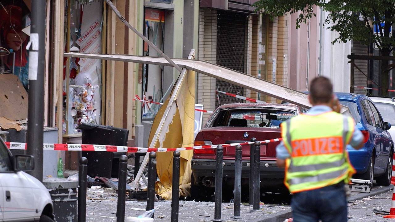 Ein Polizist steht nach einer Explosion an einem Tatort.