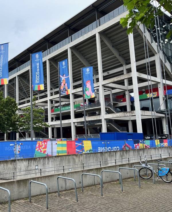 Blick auf das Kölner Stadion, das in EM-Farben und Fahnen gehüllt ist.