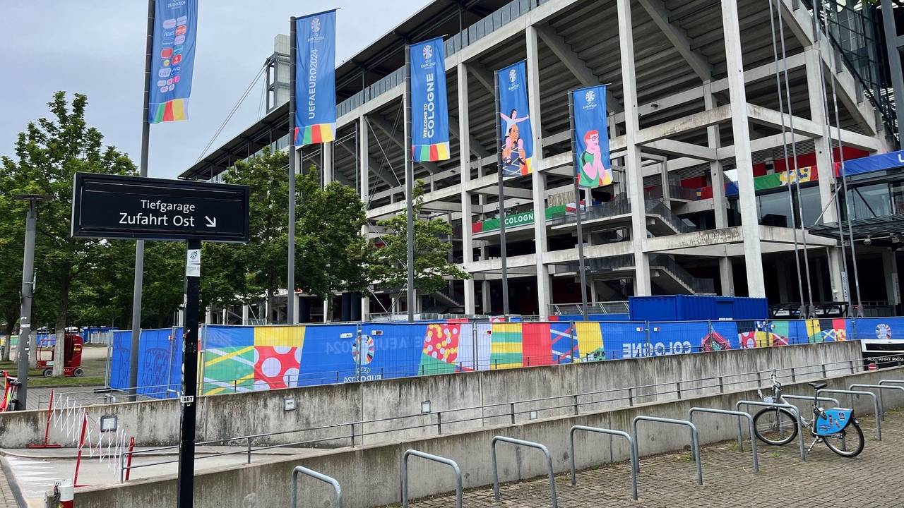 Blick auf das Kölner Stadion, das in EM-Farben und Fahnen gehüllt ist.