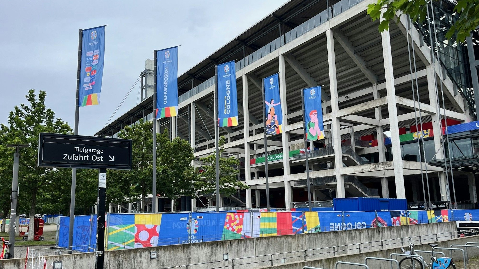 Blick auf das Kölner Stadion, das in EM-Farben und Fahnen gehüllt ist.