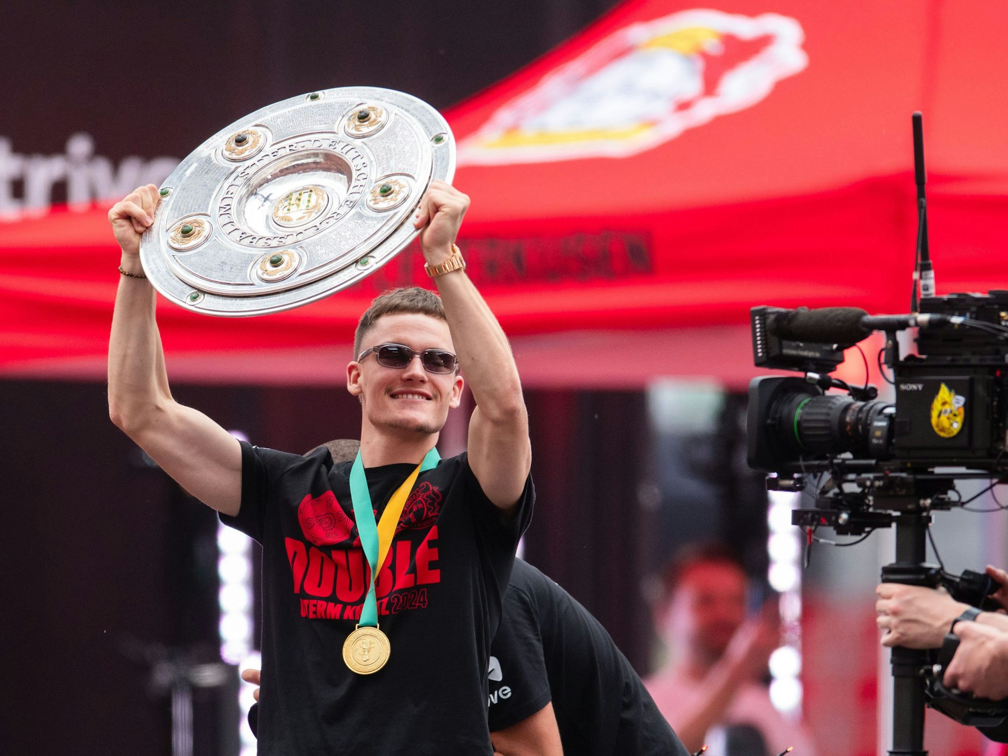 Leverkusens Florian Wirtz präsentiert bei der Meisterfeier in der BayArena die Meisterschale.