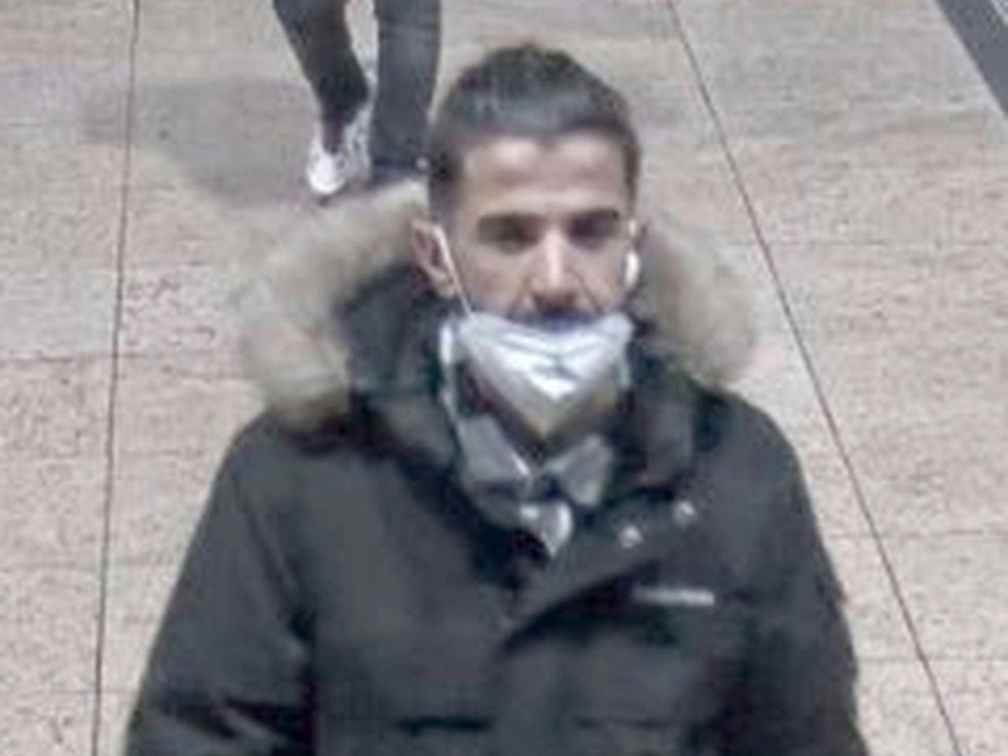 Ein Mann geht mit einer Corona-Maske durch den Kölner Hauptbahnhof.