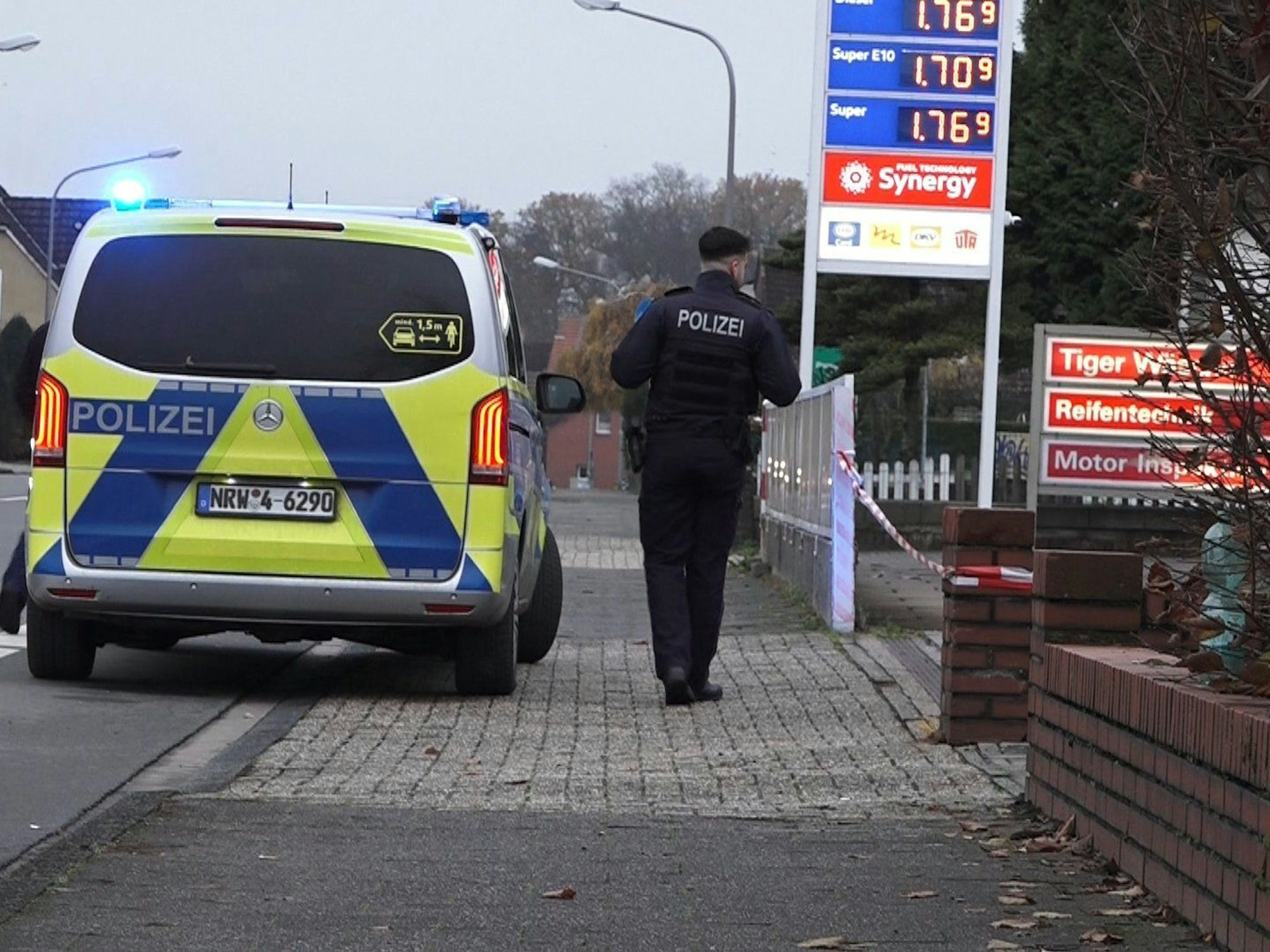 Ein Polizeifahrzeug steht vor einer Tankstelle.