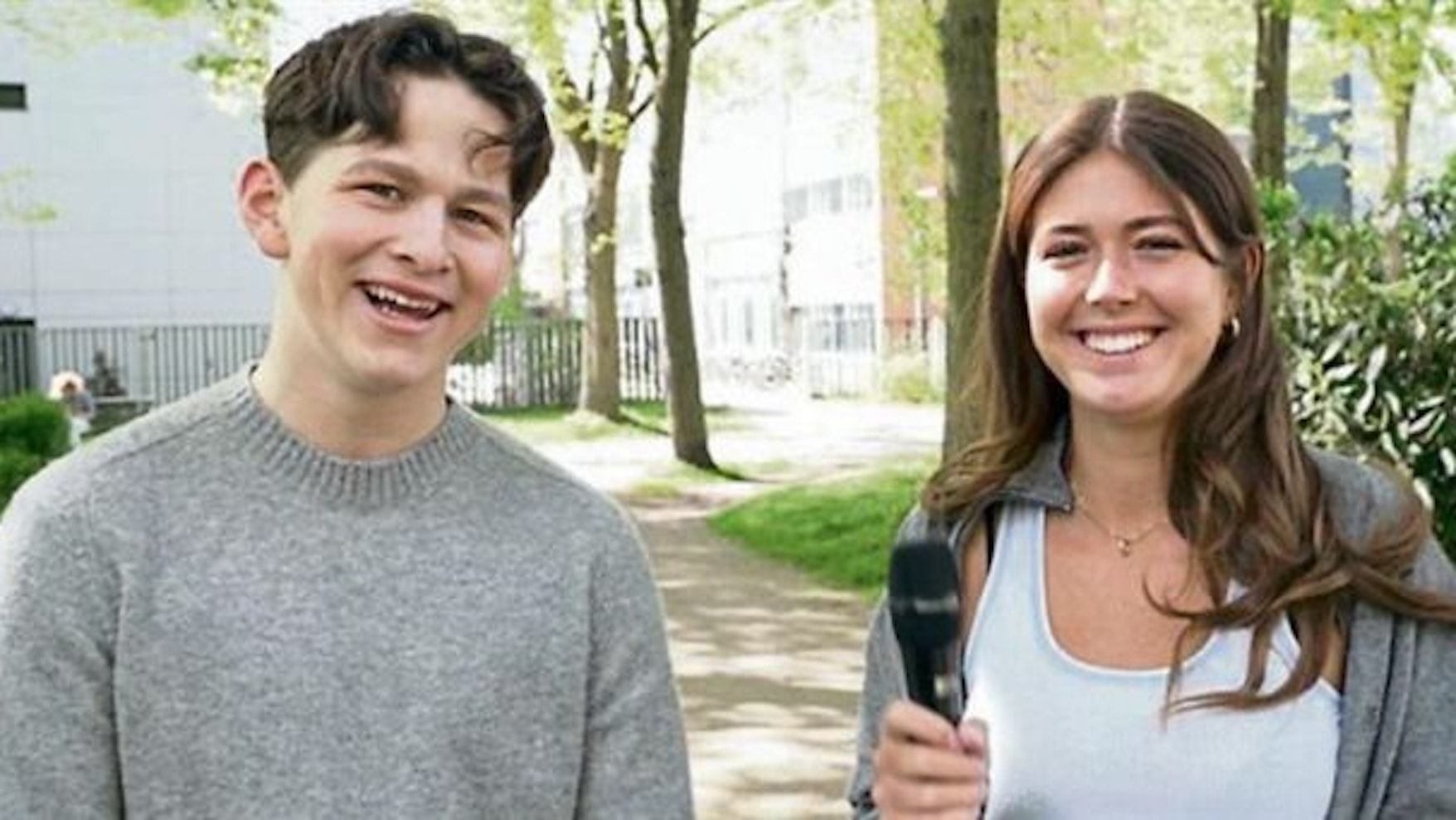Laura hält ein Mikrofon in der Hand, Julius steht neben ihr.