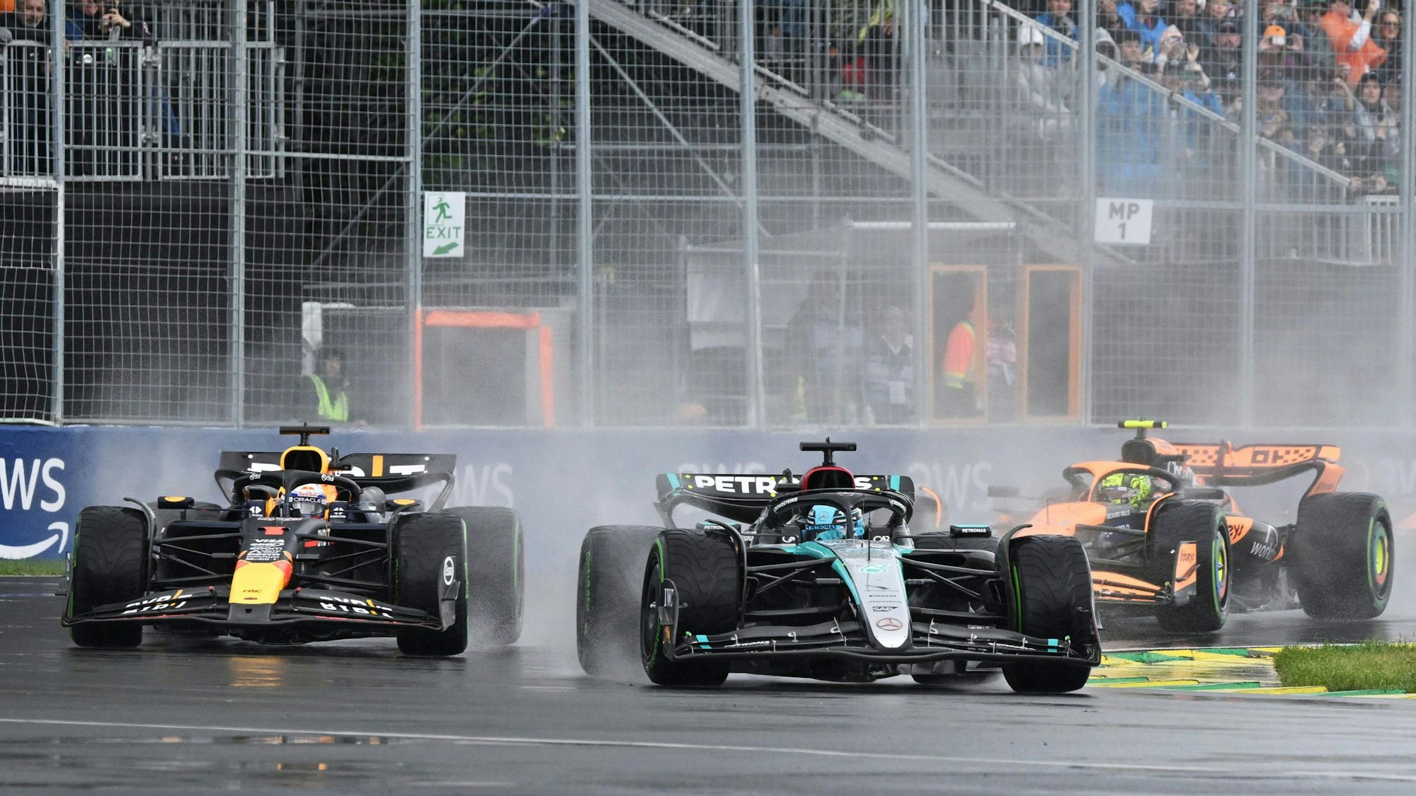 Mercedes-Pilot George Russell führt Red Bull Racing-Pilot Max Verstappen und McLaren-Pilot Lando Norris durch die erste Kurve.
