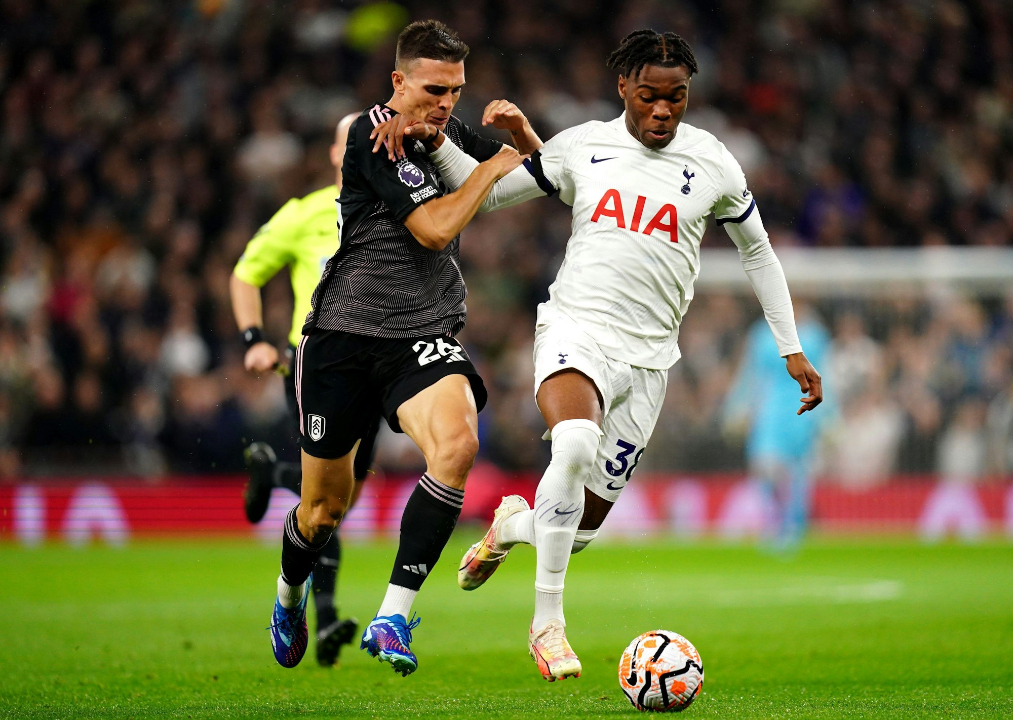 Fulhams Joao Palhinha (l) und Tottenham Hotspurs Destiny Udogie kämpfen um den Ball.