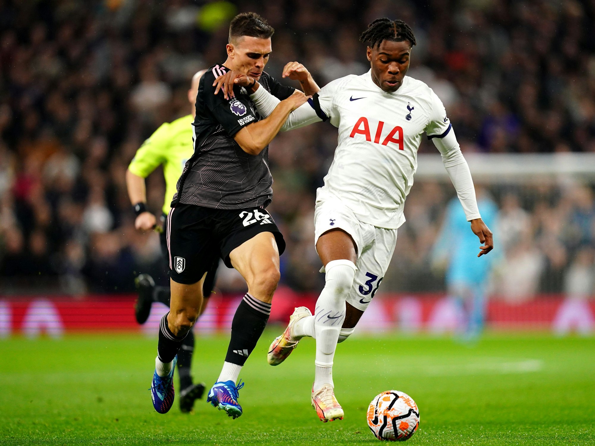 Fulhams Joao Palhinha (l) und Tottenham Hotspurs Destiny Udogie kämpfen um den Ball.