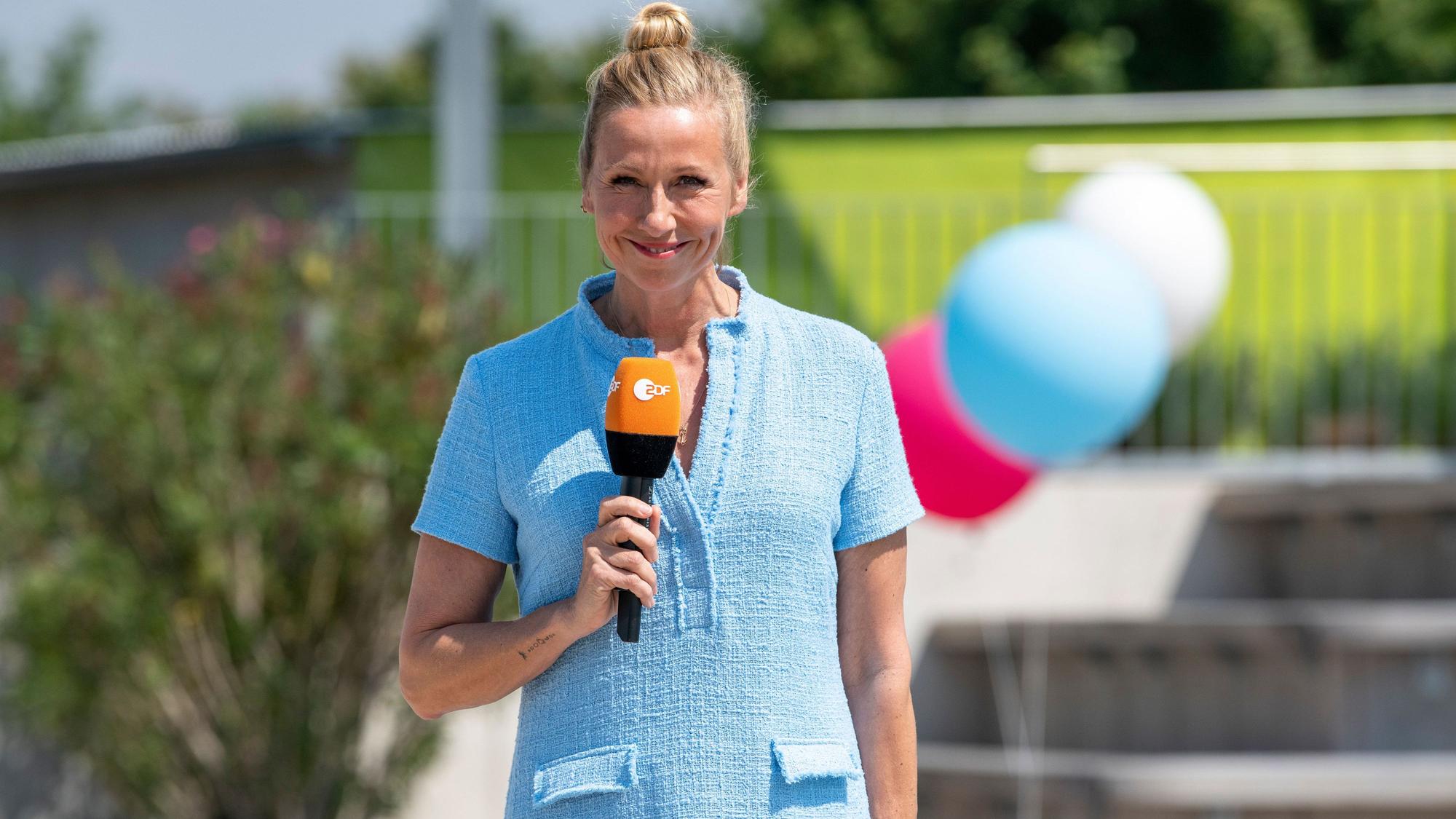 Moderatorin Andrea Kiewel steht im "Fernsehgarten" und lächelt in die Kamera.