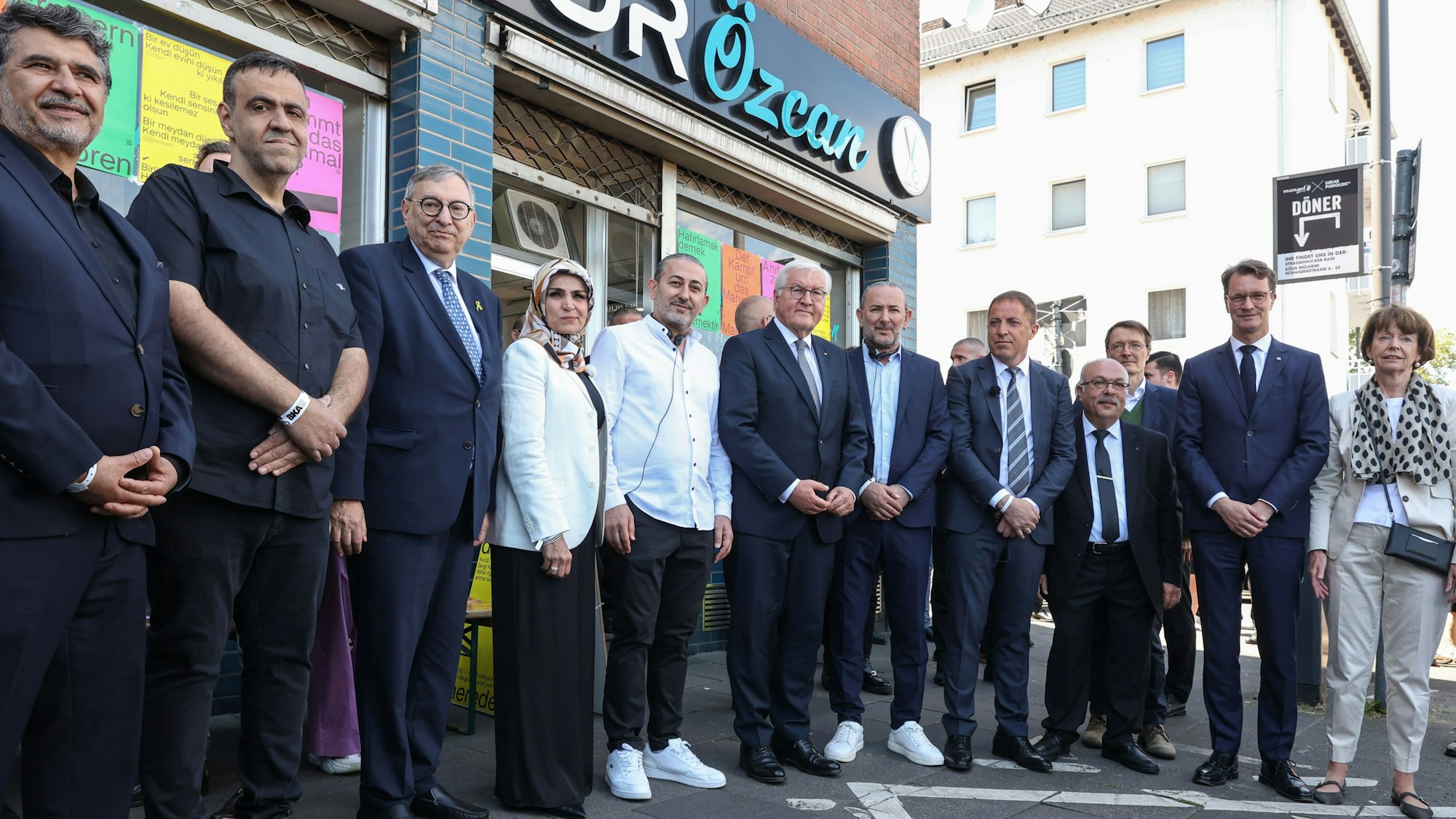 Vor dem Friseursalon Özcan in der Keupstraße: unter anderem mit Bundespräsident Frank-Walter Steinmeier, Ministerpräsident Hendrik Wüst und Kölns Oberbürgermeisterin Henriette Reker