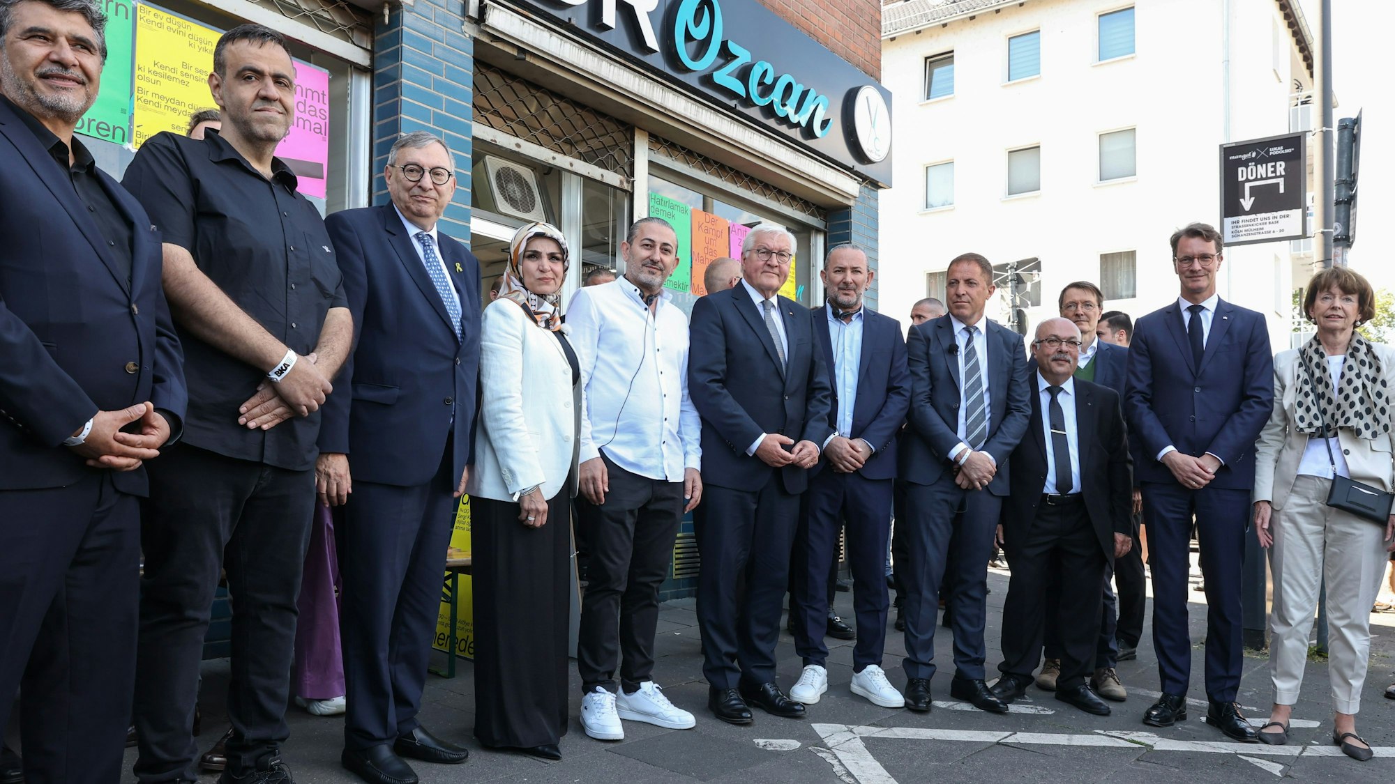 Vor dem Friseursalon Özcan in der Keupstraße: unter anderem mit Bundespräsident Frank-Walter Steinmeier, Ministerpräsident Hendrik Wüst und Kölns Oberbürgermeisterin Henriette Reker