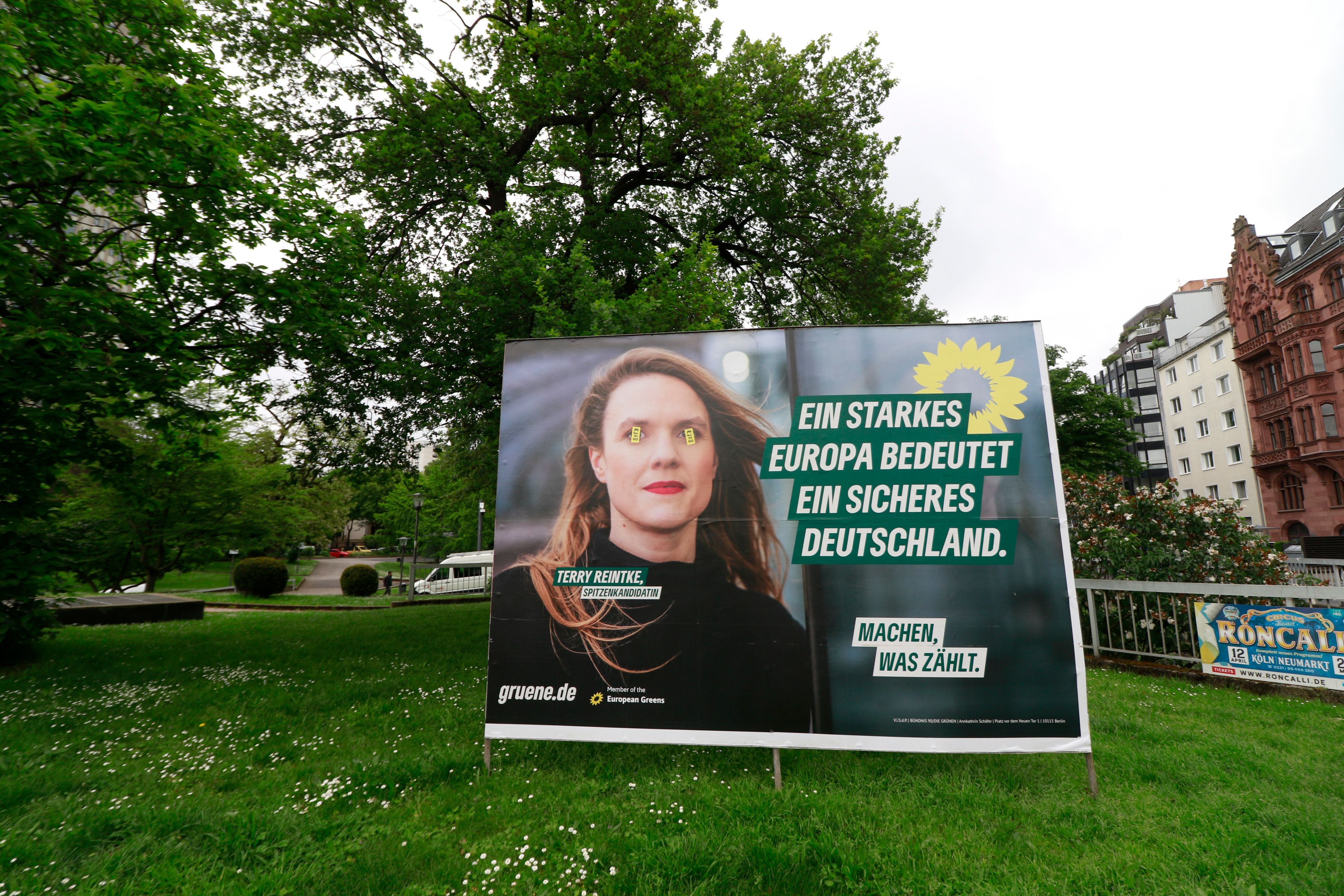 Ein Wahlplakat zur Europawahl von den Grünen am Ebertplatz ist mit Aufklebern teilweise überklebt.