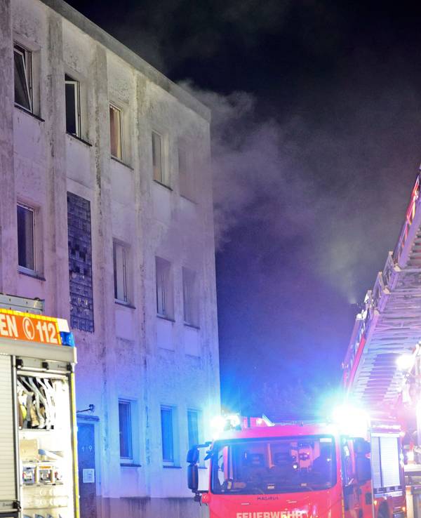 Rauch kommt aus den Fenstern eines Mehrfamilienhauses. Bei dem Hausbrand in Solingen sind etliche Menschen verletzt worden, darunter auch die Besatzung des ersten eingetroffenen Rettungswagen.