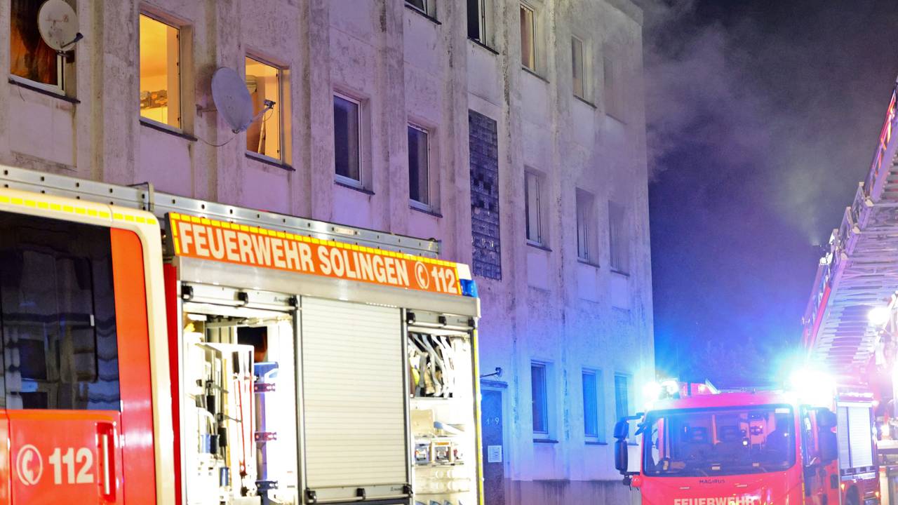Rauch kommt aus den Fenstern eines Mehrfamilienhauses. Bei dem Hausbrand in Solingen sind etliche Menschen verletzt worden, darunter auch die Besatzung des ersten eingetroffenen Rettungswagen.